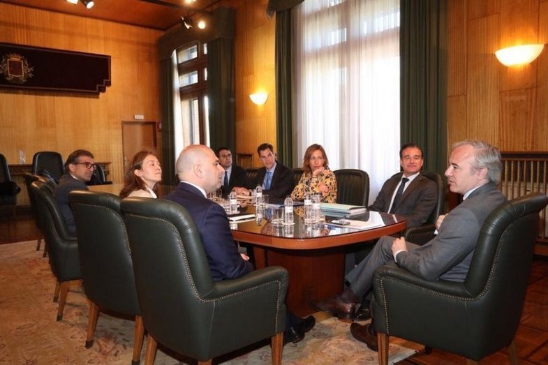 Davide Ciciliato, director general de Endesa X (izquierda) y Jorge Azc&oacute;n, alcalde de Zaragoza (derecha) junto al resto de la comitiva durante la presentaci&oacute;n que ha tenido lugar en el ayuntamiento de la ciudad.